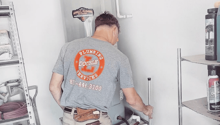 Double L Plumbing technician servicing a water heater in Azle, TX.
