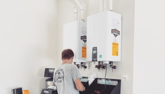 Licensed Double L Plumbing technician installing dual tankless water heaters for a home in Weatherford, TX.